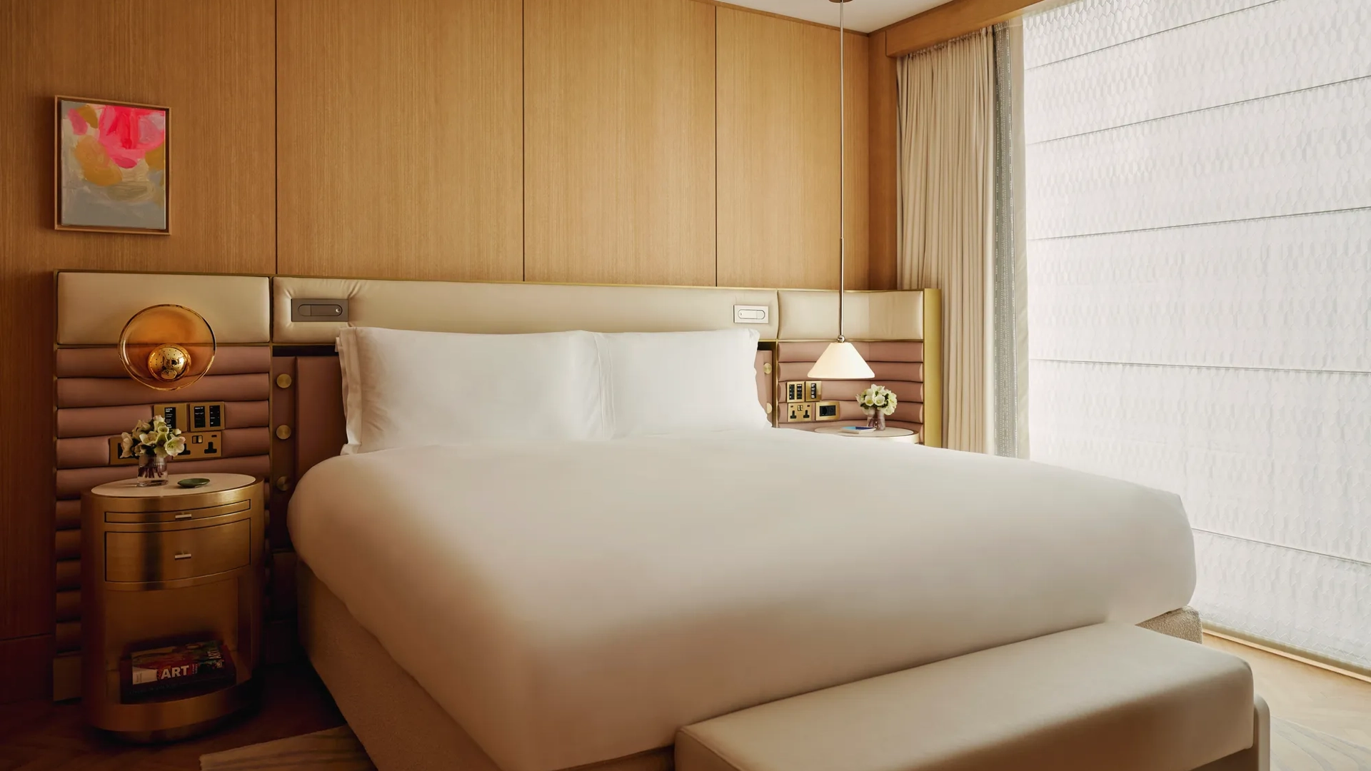 A tidy bedroom with a neatly made bed, soft lighting, and simple furniture.