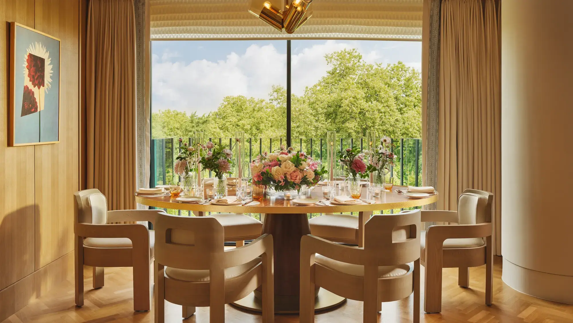 A dining table set inside a hotel room with chairs and neatly arranged place settings
