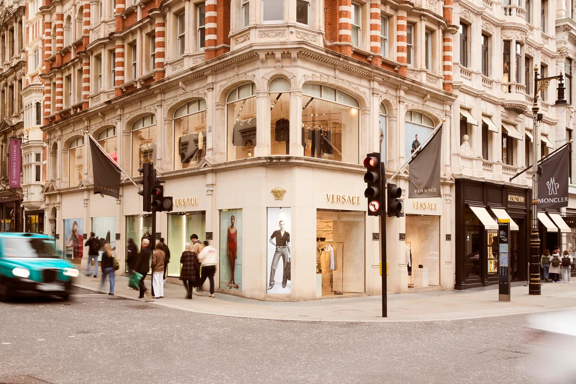 Street view of New Bond Street with luxury storefronts, elegant façades, and pedestrians walking along the upscale shopping district.