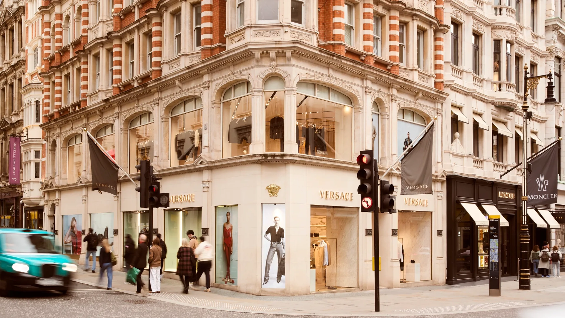 Street view of New Bond Street with luxury storefronts, elegant façades, and pedestrians walking along the upscale shopping district.