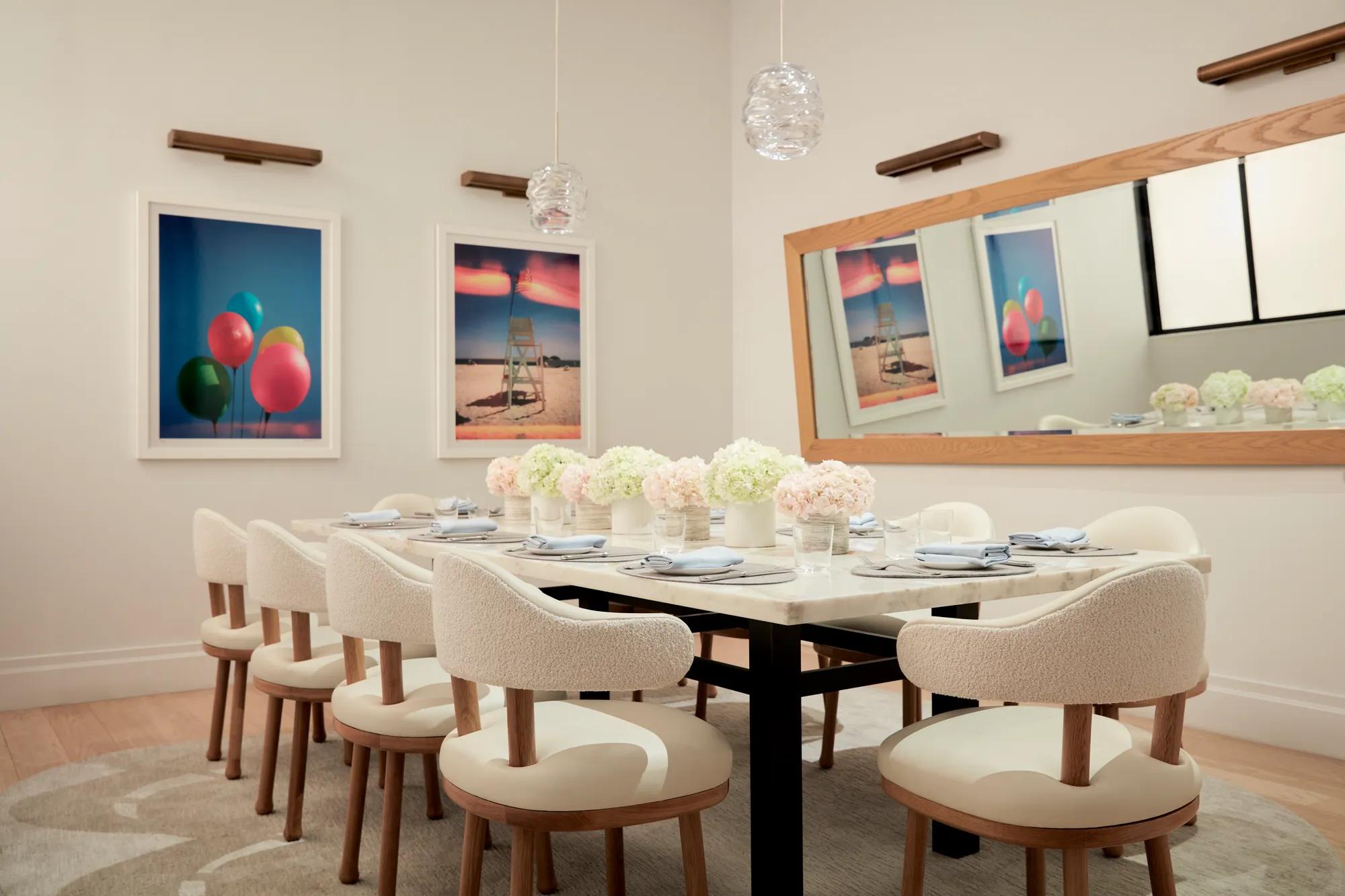 Elegant private dining room with floral arrangements and modern artwork on the walls.