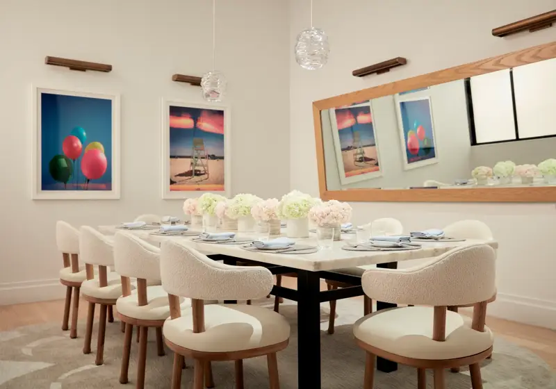Elegant private dining room with floral arrangements and modern artwork on the walls.