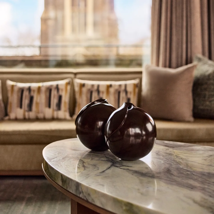 A marble coffee table with two brown vases placed side by side.