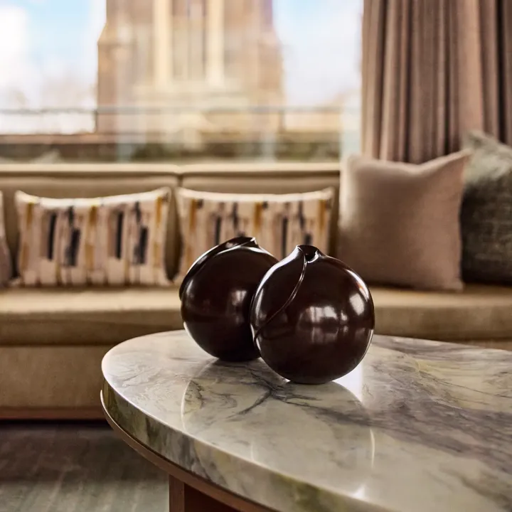A marble coffee table with two brown vases placed side by side.