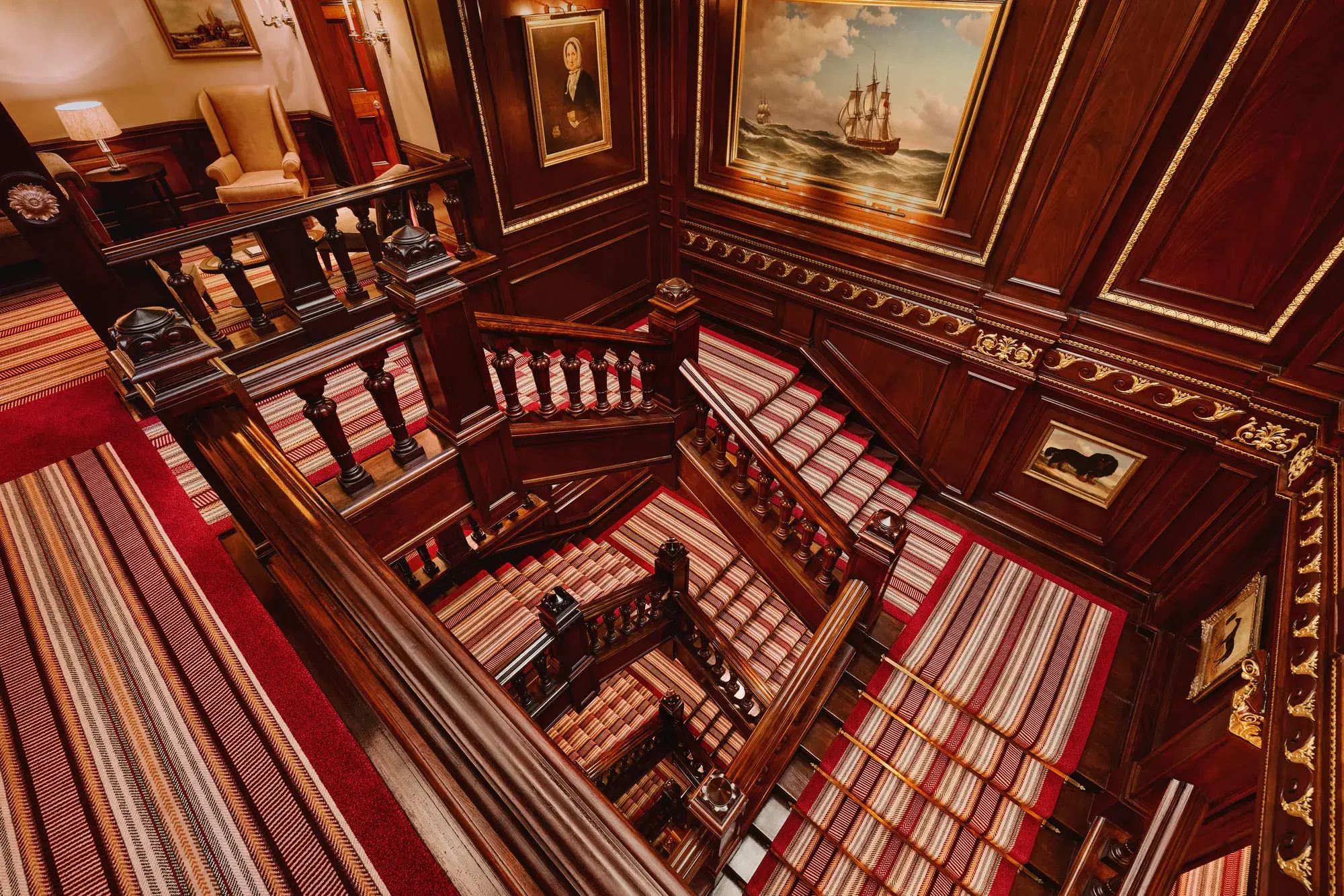The grand staircase at The Connaught with its elegant curved banister and soft lighting