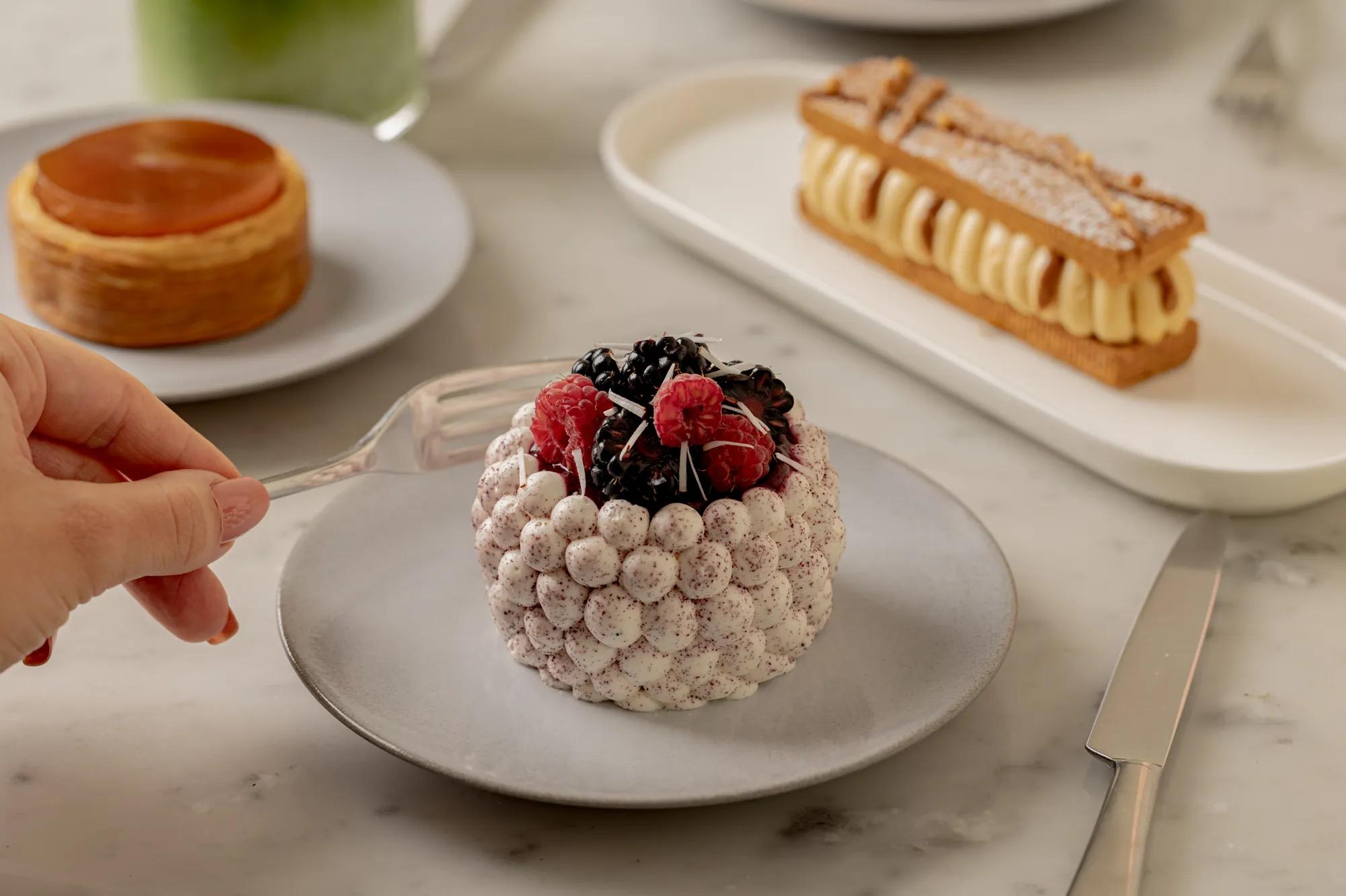 Berry-topped meringue dessert served alongside elegant French pâtisserie favourites.
