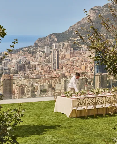 Une installation pour un événement privé sur la pelouse du Maybourne Riviera, avec un décor élégant, des tables soigneusement dressées et une vue dégagée sur le littoral méditerranéen.