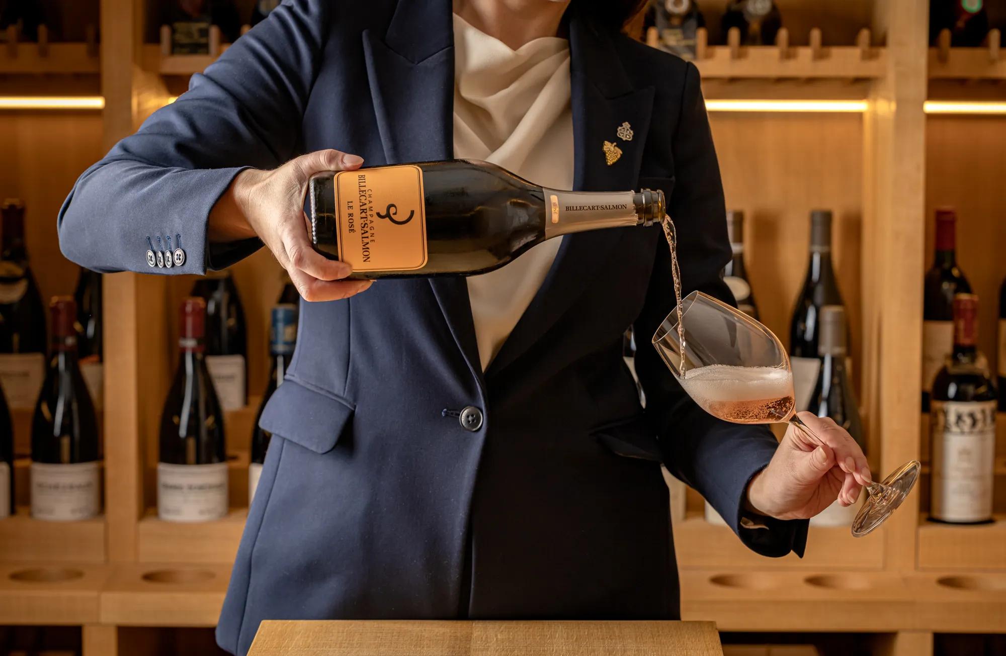 Sommelier pouring Billecart-Salmon Champagne in Claridge’s Wine Cellar, surrounded by an extensive wine collection.
