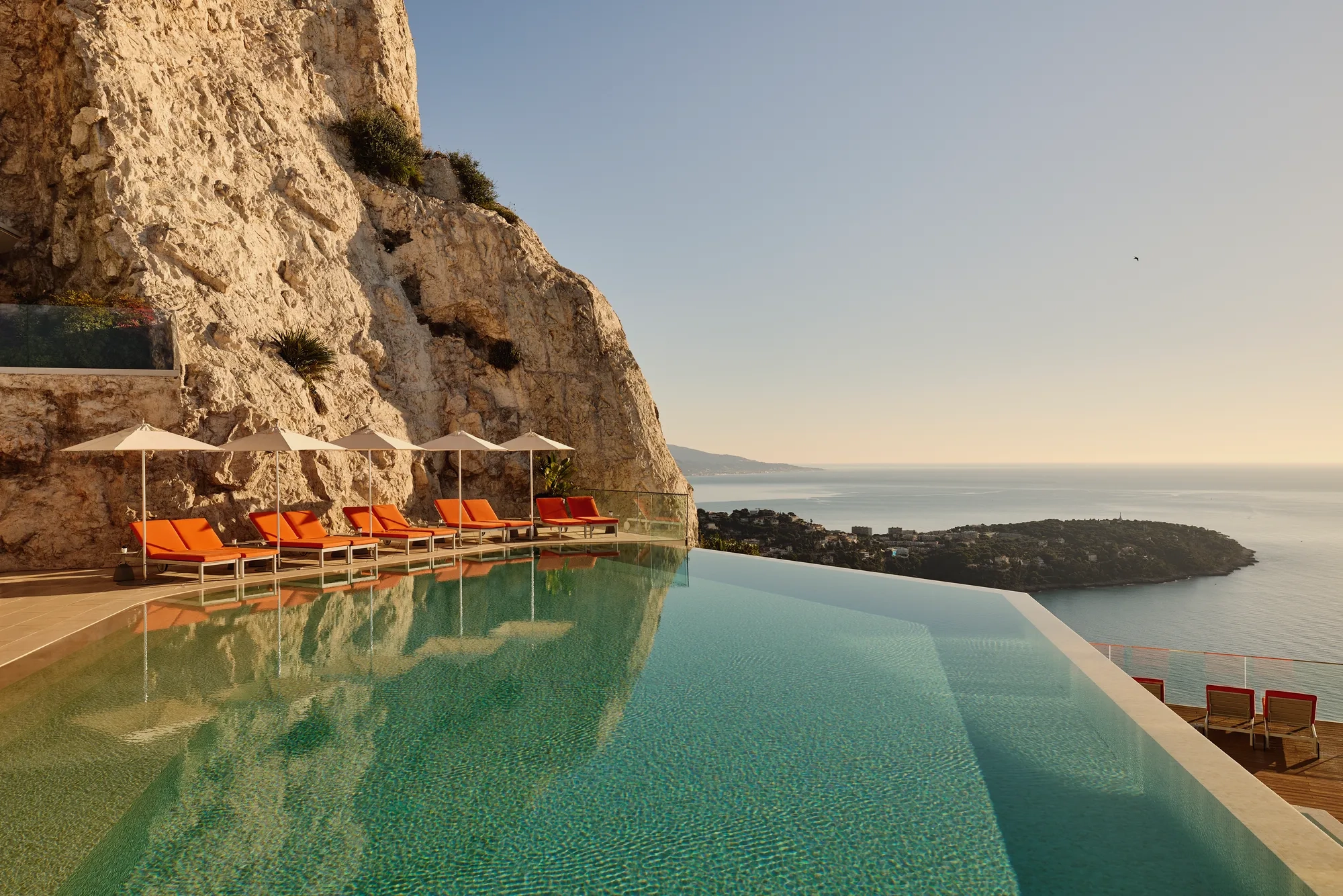 Une piscine paisible du Maybourne Riviera, au design contemporain épuré et offrant de vastes vues sur le littoral méditerranéen.